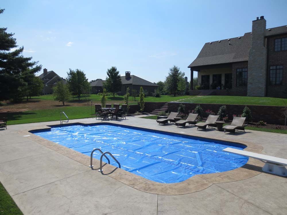 A large swimming pool with a blue cover on it