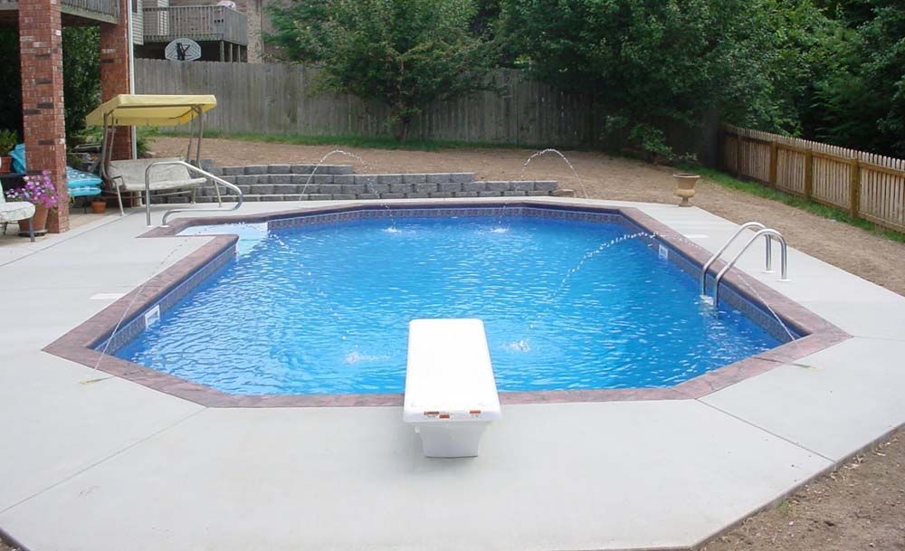 A large swimming pool with a diving board in the middle of it.