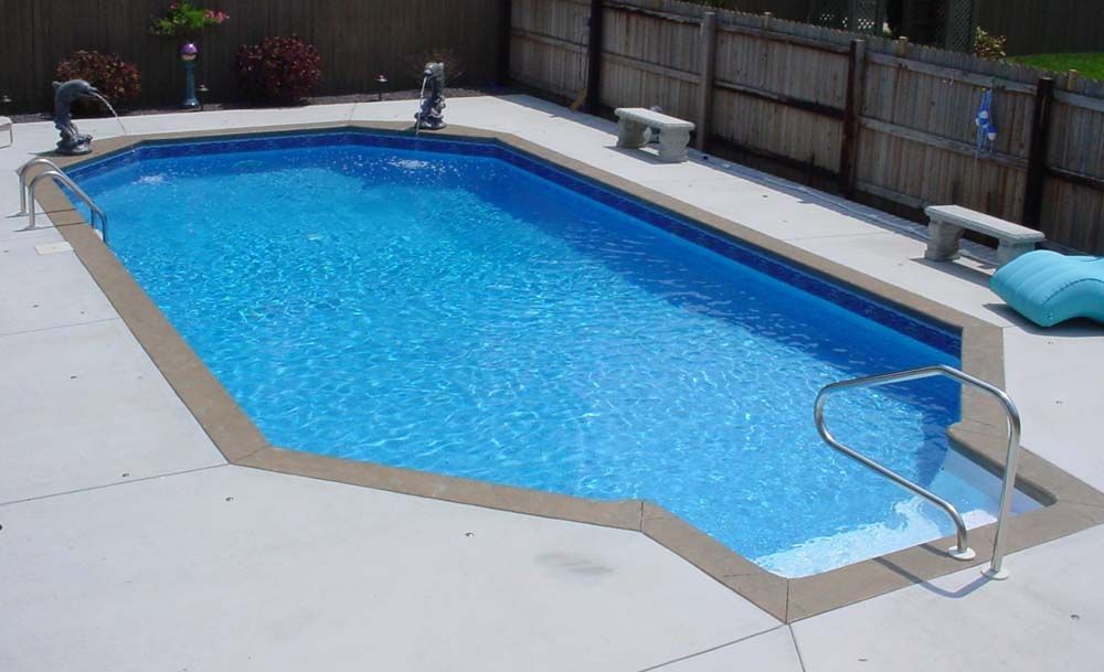 A large swimming pool with a fence in the background