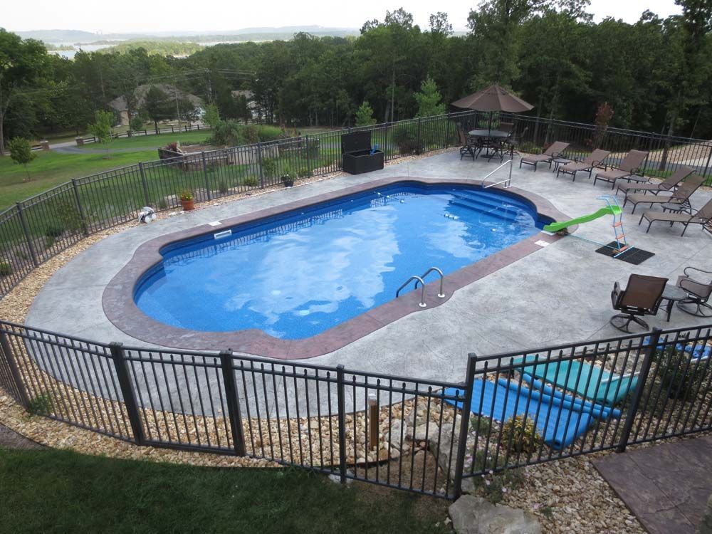An aerial view of a large swimming pool surrounded by a fence.