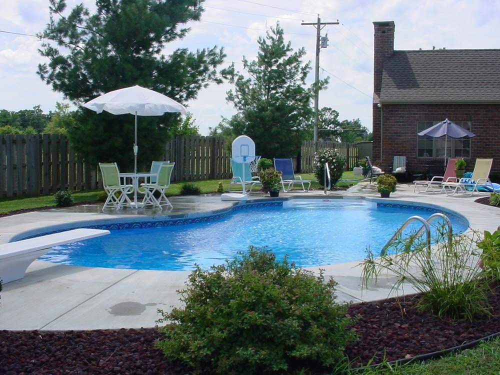 A large swimming pool surrounded by chairs and umbrellas
