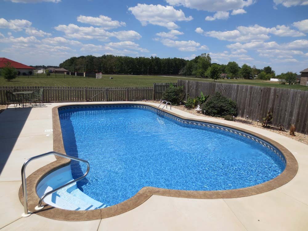 A large swimming pool with a wooden fence around it