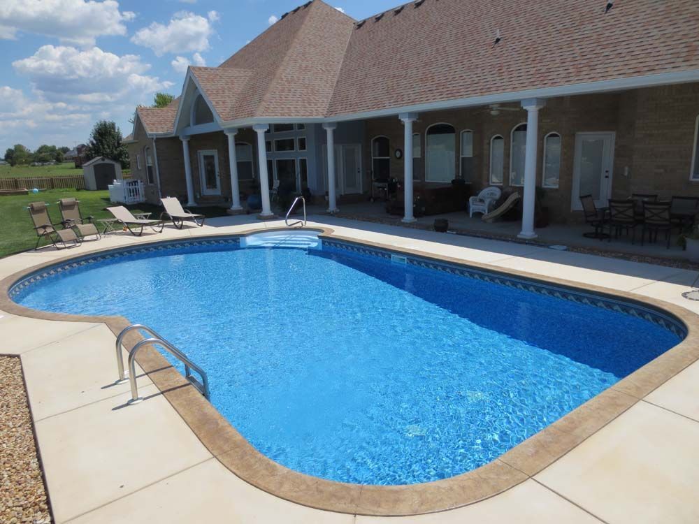 A large swimming pool in front of a house