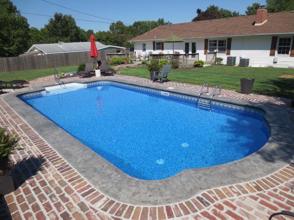 A large blue swimming pool in front of a house
