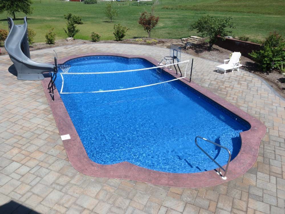 A large swimming pool with a slide and volleyball net