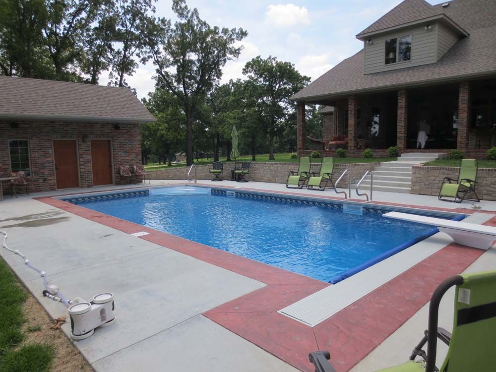 A large swimming pool in front of a large house