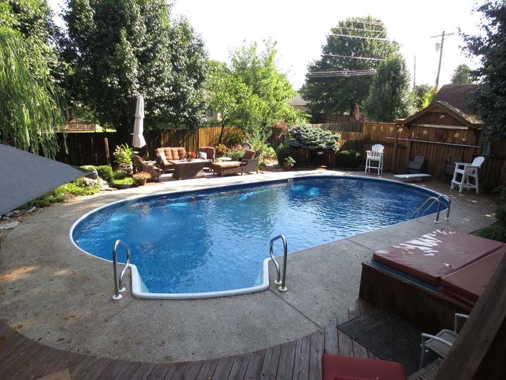 A large oval shaped swimming pool in a backyard