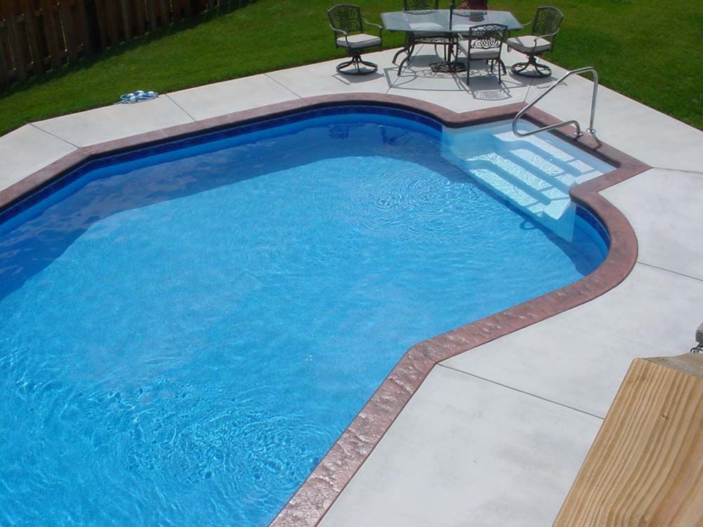 A swimming pool with a table and chairs in it