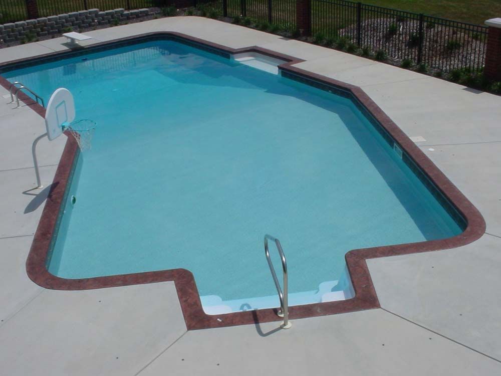 A large swimming pool with a basketball hoop in the middle