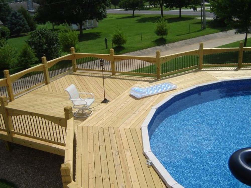 A large wooden deck overlooking a swimming pool