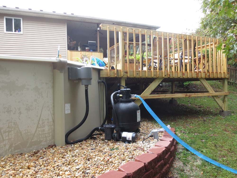 A hose is attached to the side of a house next to a deck