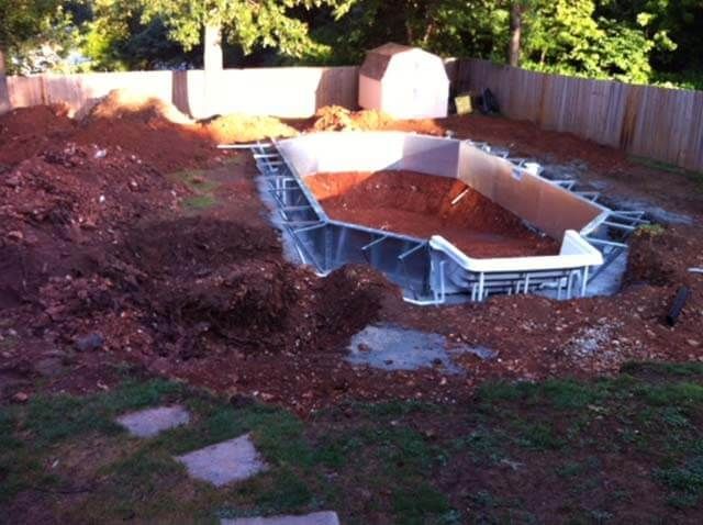 A swimming pool is being built in a backyard