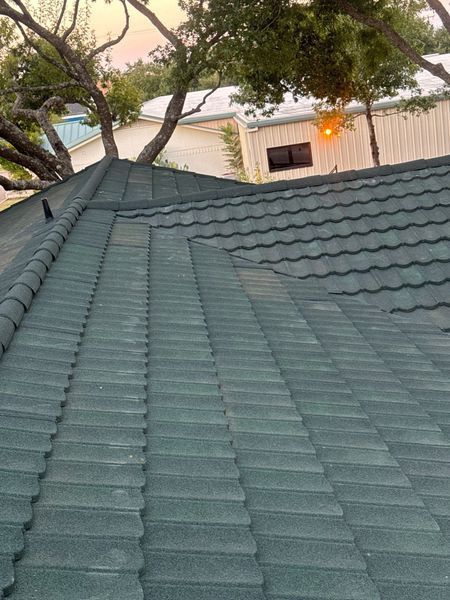 Green metal roof with textured, overlapping tiles.