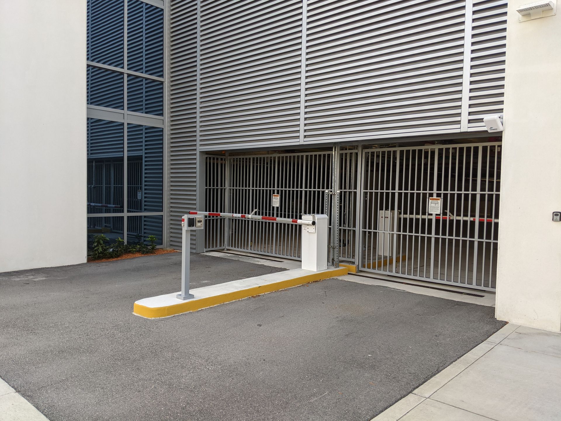 Accessible parking entrance with a barrier gate in front of a building garage
