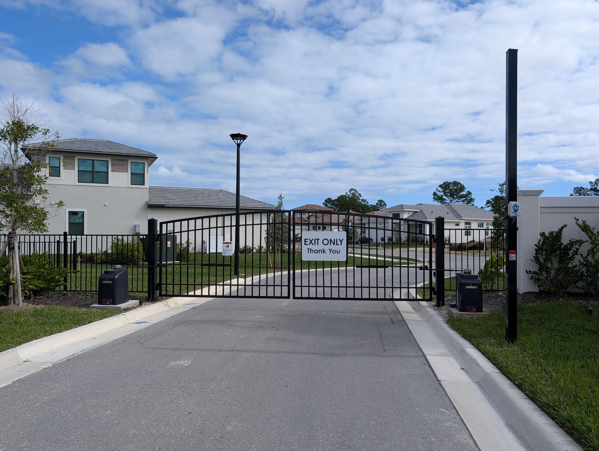 Gated entrance to a residential complex with a “Private Property” sign and paved driveway.
