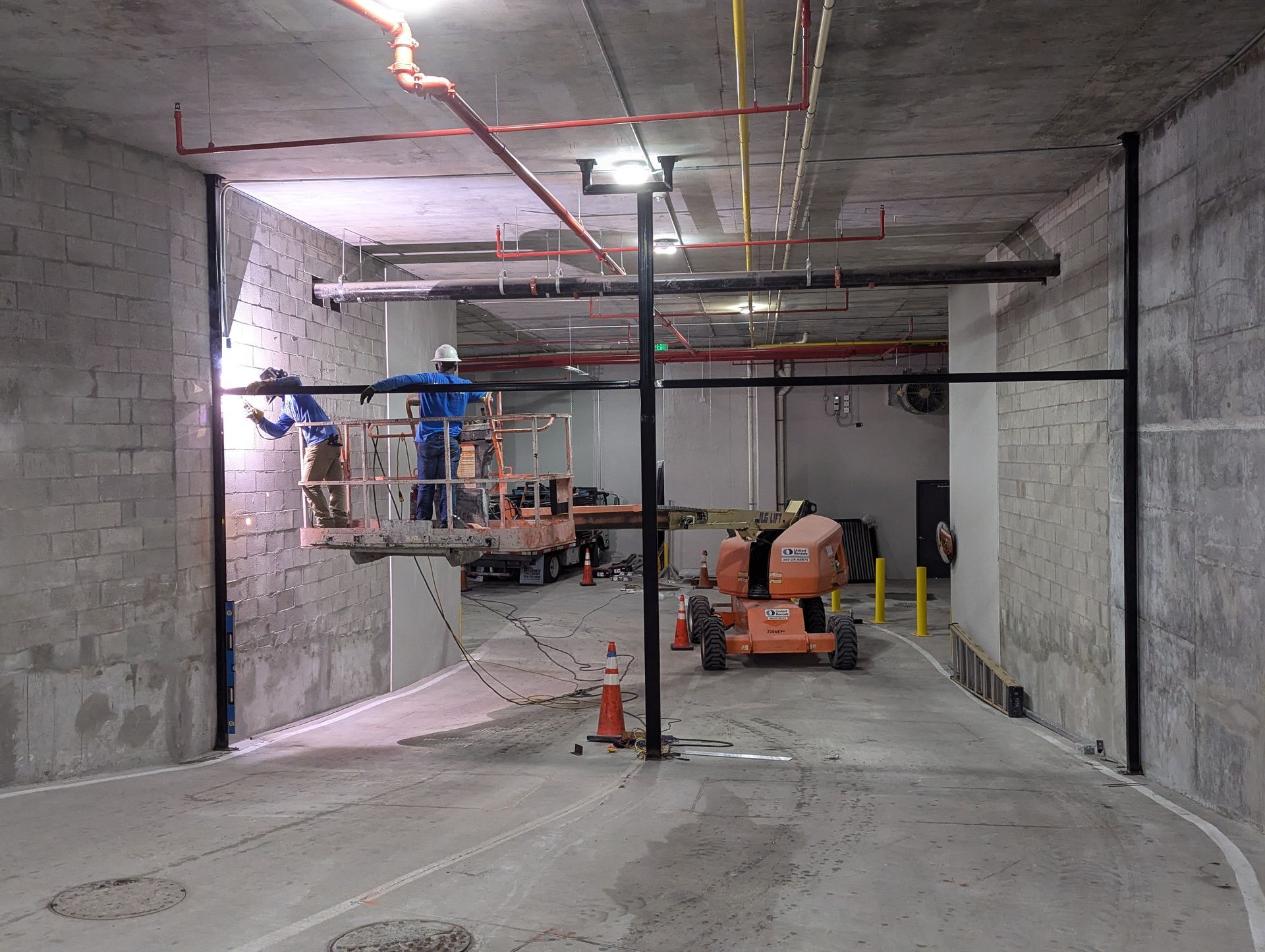 Construction workers and lift in a concrete tunnel under construction