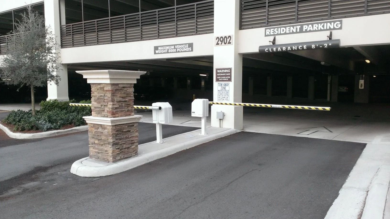 Accessible parking entrance with a ramp, curb cut, and covered garage entry