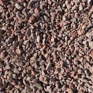 Close-up view of reddish-brown gravel stones, irregularly shaped and textured, tightly packed together.