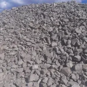 Pile of gray gravel against a cloudy blue sky.