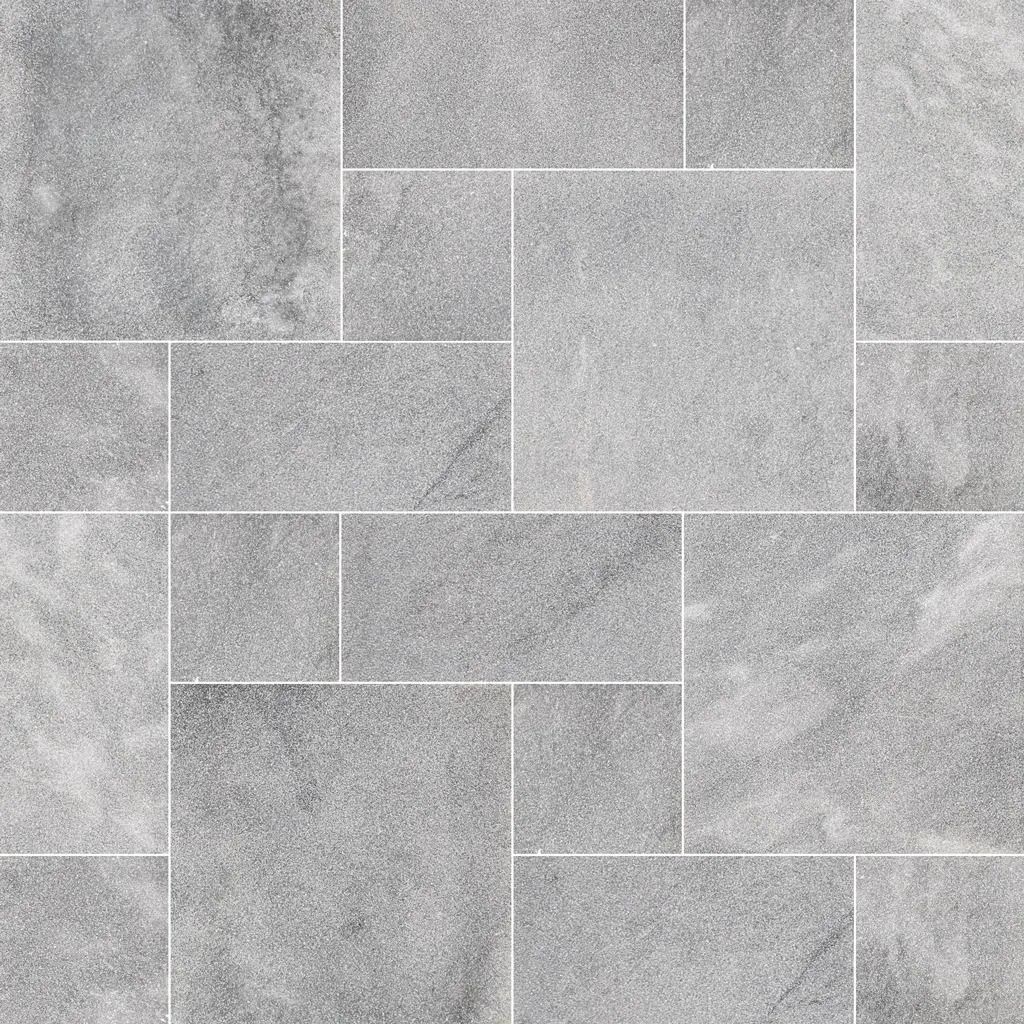 Gray rectangular and square tiles arranged in a random pattern, with white grout lines.