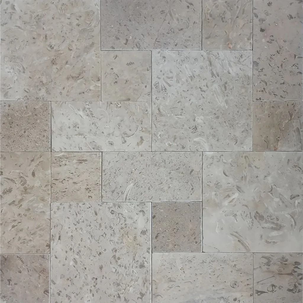Gray-beige stone tiles in various rectangular sizes arranged in a pattern.
