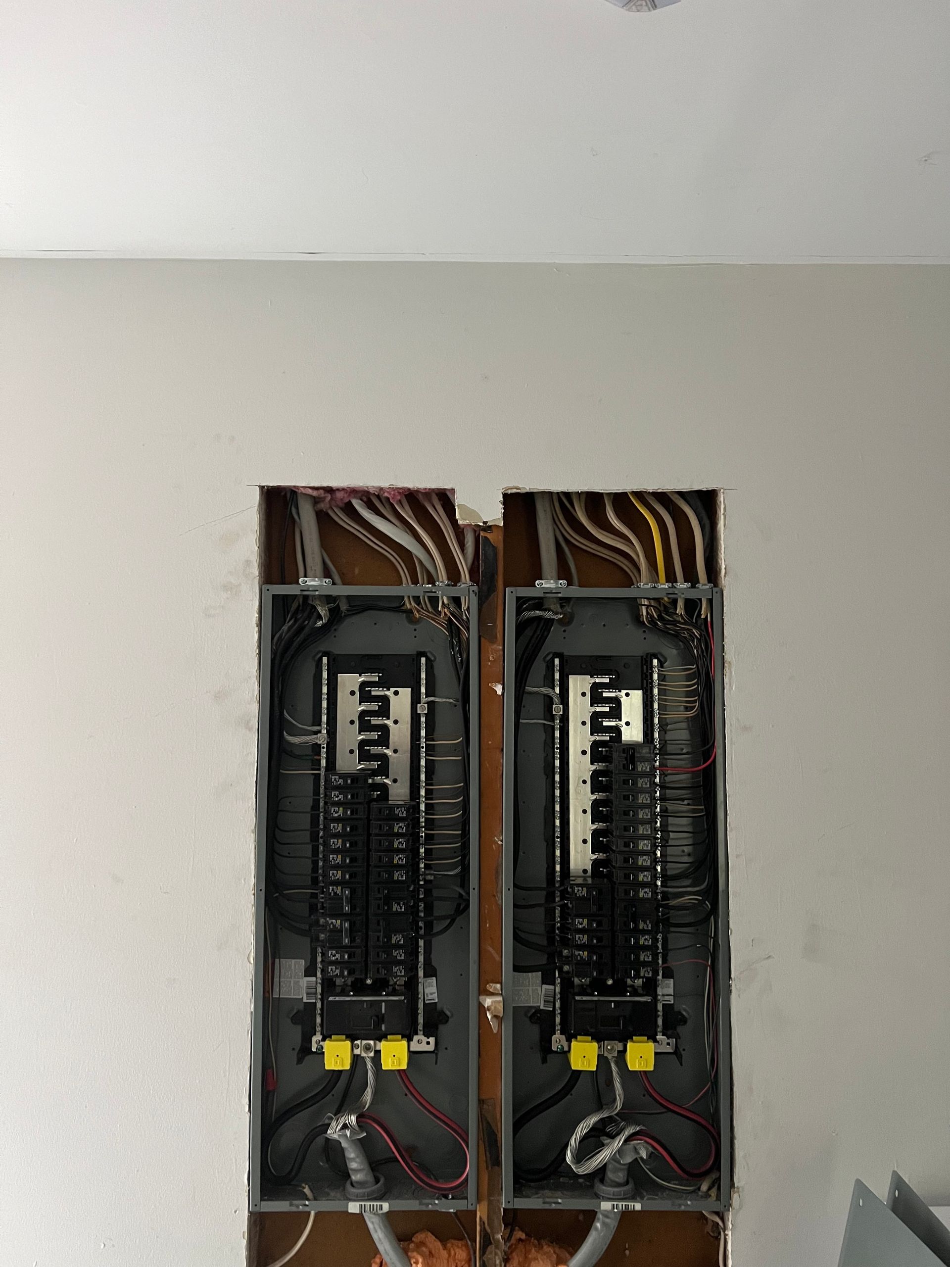 Two electrical panels are sitting next to each other on a wall.