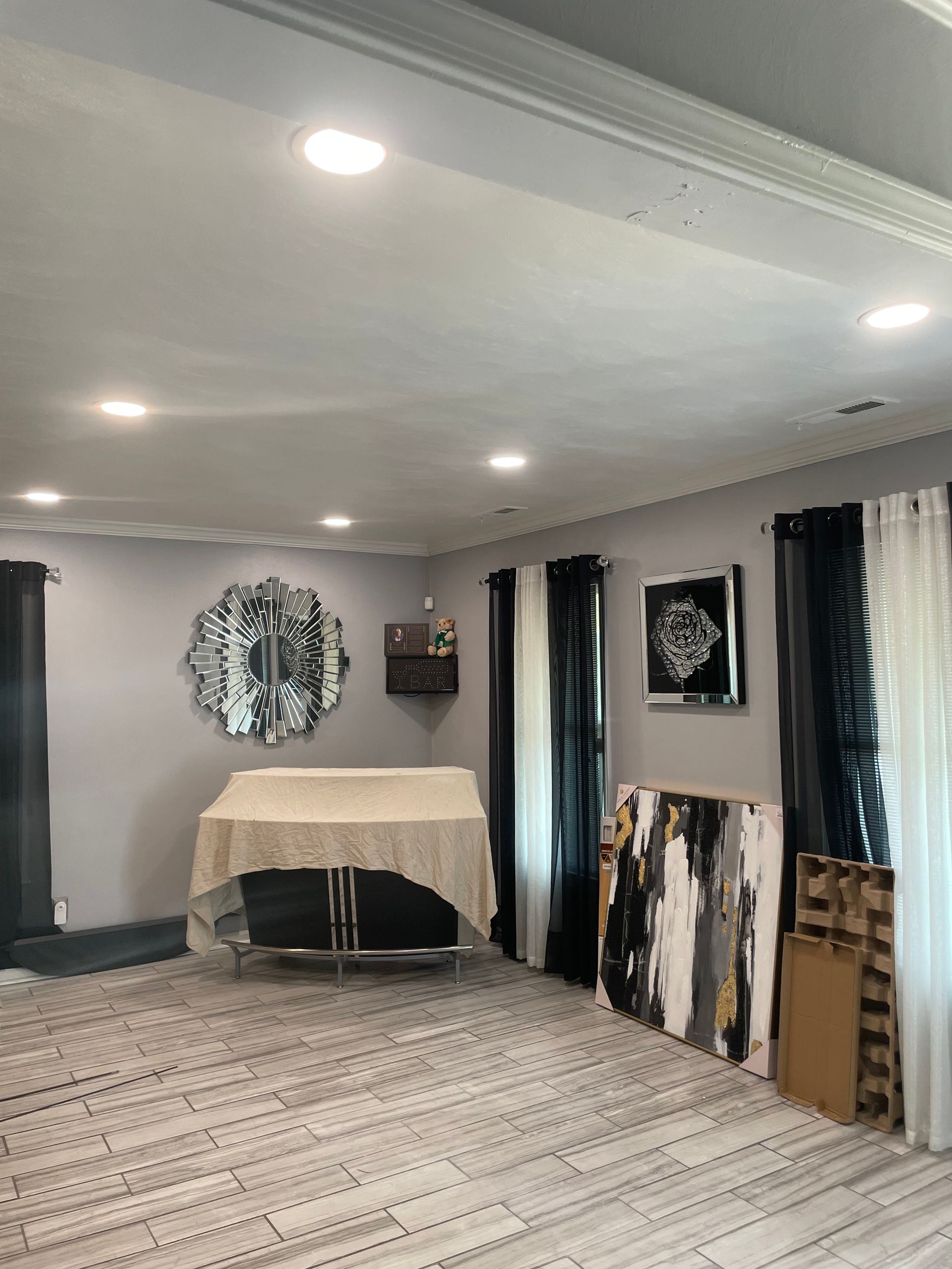 A living room with a table and paintings on the wall.