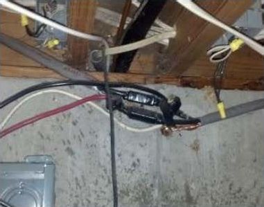 A bunch of wires are hanging from the ceiling of a house