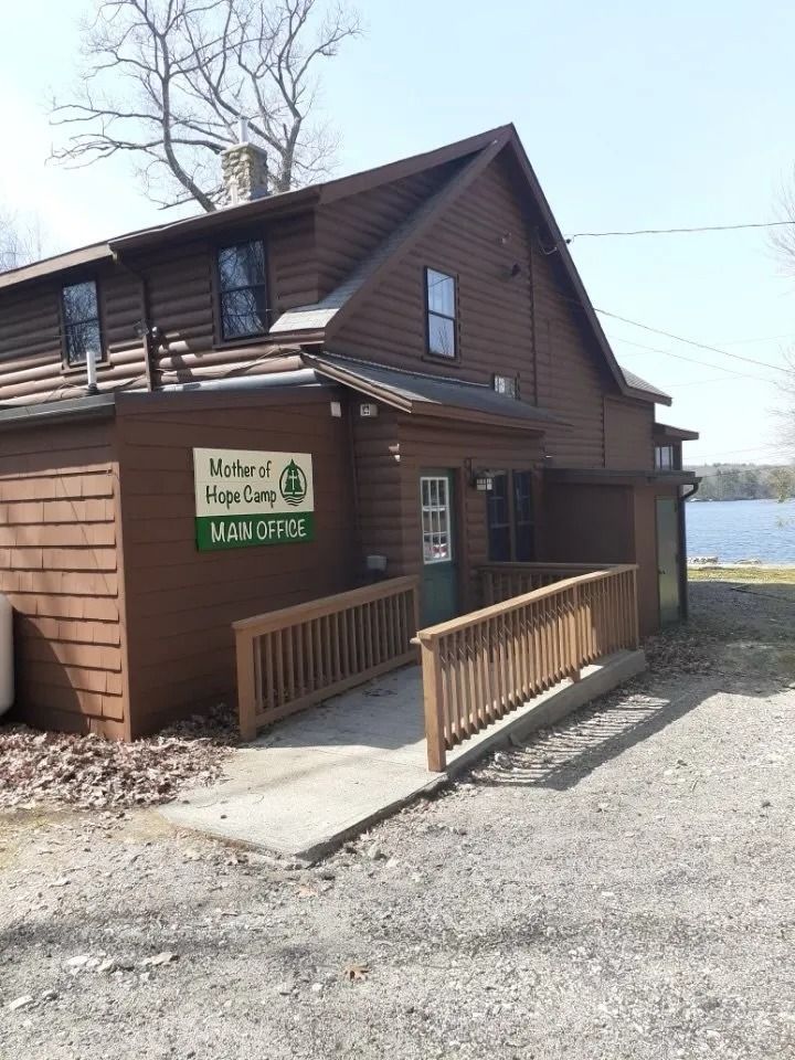 Brown cabin with a ramp, sign reading 