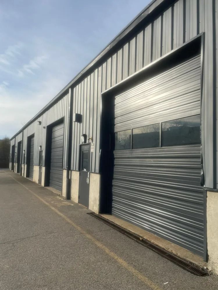 Exterior of industrial metal building with multiple closed garage doors.