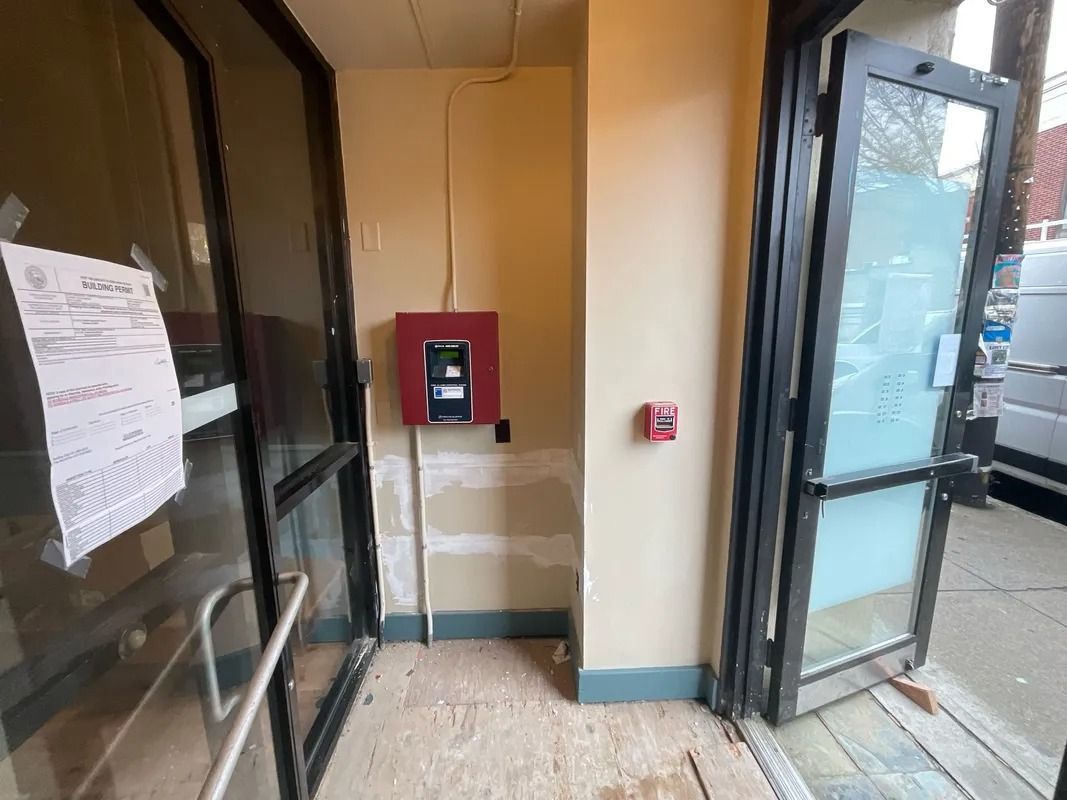 Entranceway with open doors, a fire alarm system, and a pull station on the wall.