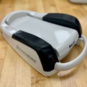 White and black Alcon Centurion Vision System device on wooden surface.