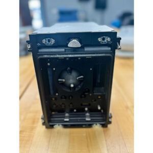 Black electronic device with various ports and buttons on a wooden surface.