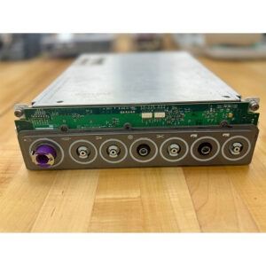 Silver and green electronic device with multiple ports on a wooden surface.