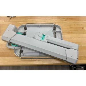 Folded gray medical scale on a wood surface.