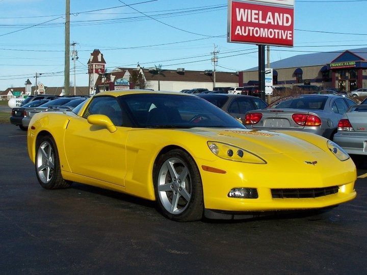 Yellow Corvette sports car in a car lot with