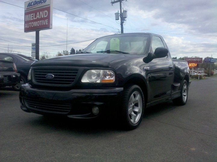 Red Chevrolet Colorado pickup truck parked on asphalt.