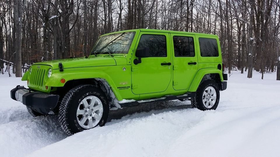 Lime green Jeep Wrangler in snow-covered landscape.