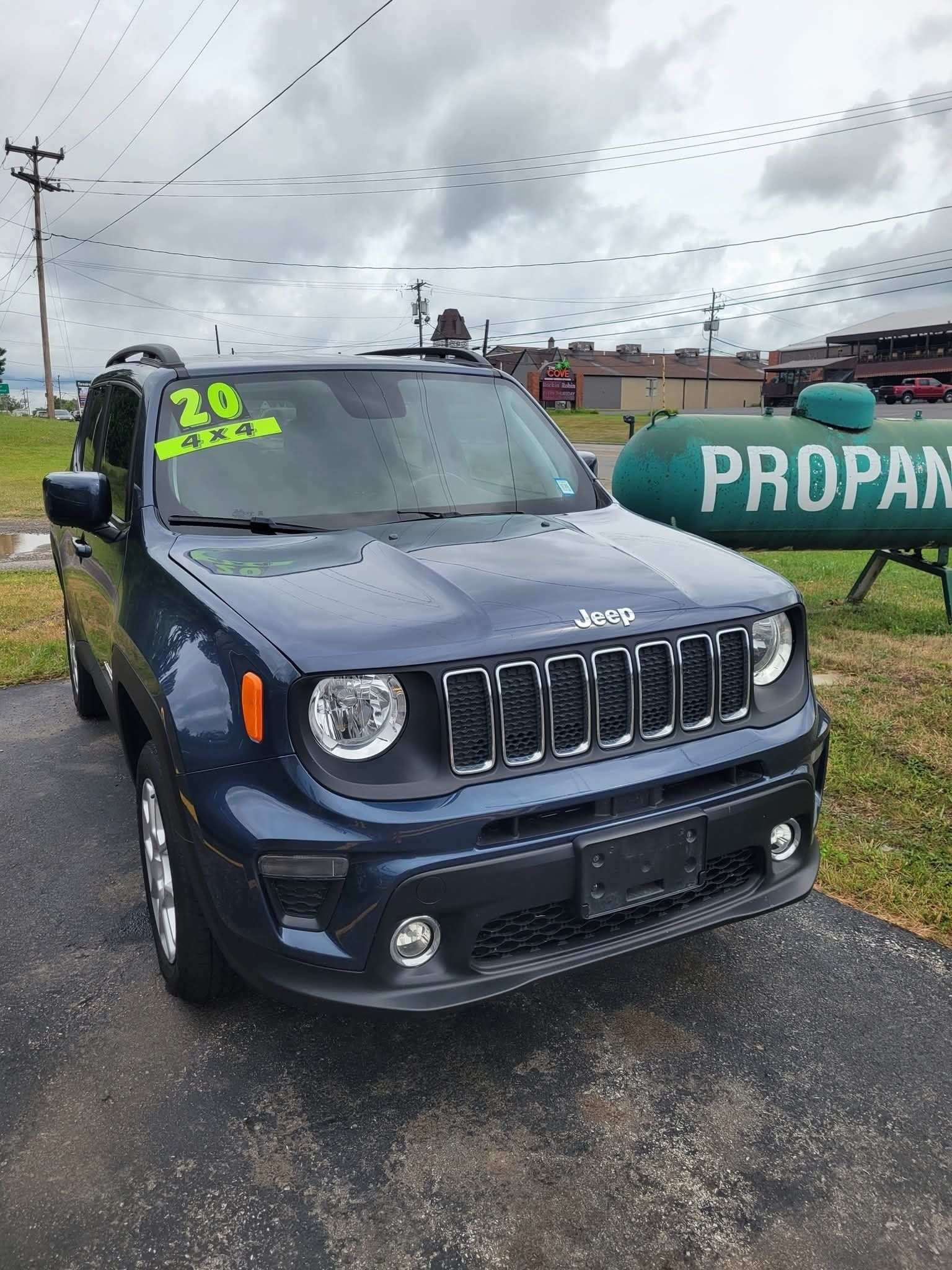 Dark blue 2020 Jeep Renegade for sale, parked outdoors on asphalt, near a propane tank.
