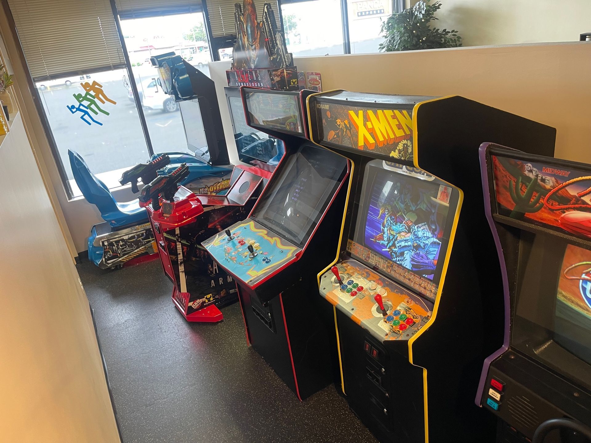 A bunch of arcade games are lined up in a room.