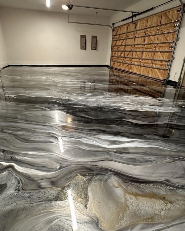 Garage with glossy black-and-white marbled epoxy floor and a partially open wooden garage door