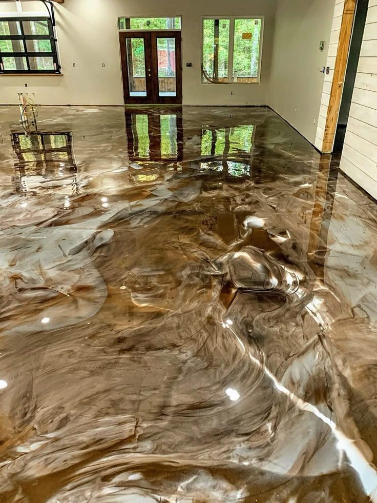 Flooded home interior with brown water covering the floor and reflecting windows and doors