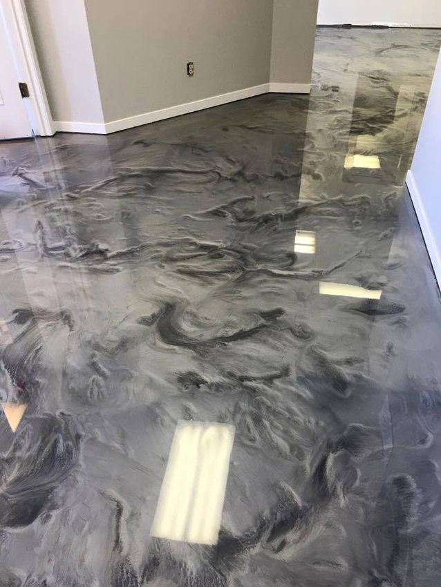 Polished gray marbled floor in an empty room with white walls and ceiling lights reflected