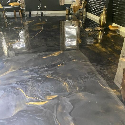 Black-and-gold marble floor in a modern interior with reflective surfaces and decor accents