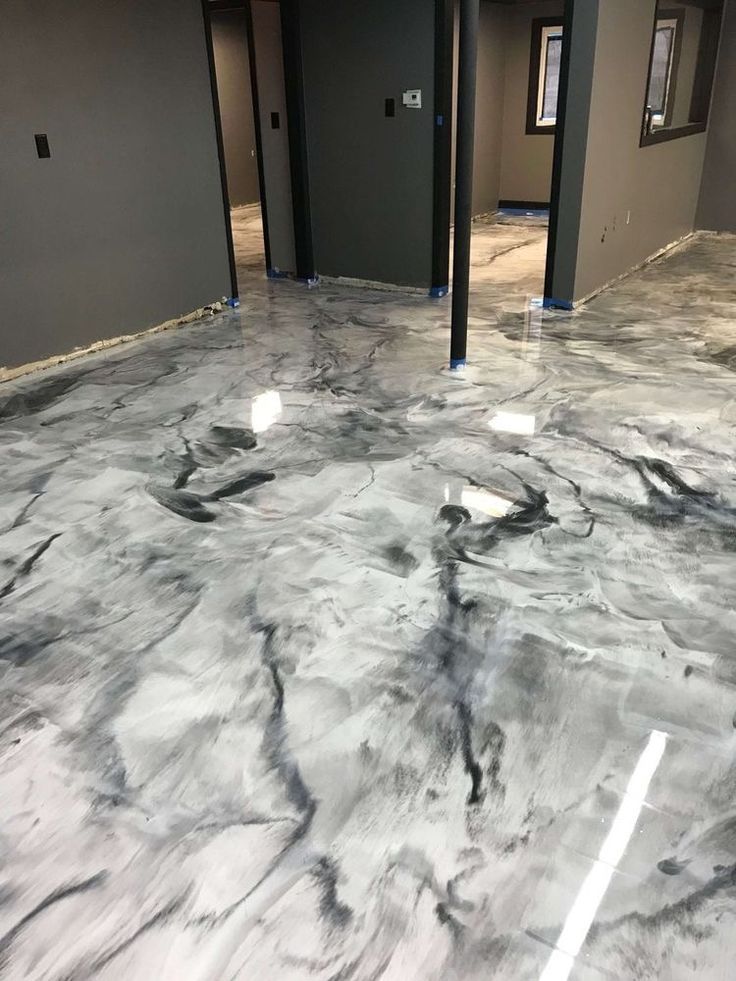 Empty room with glossy gray-and-white marbled floor and dark walls under construction