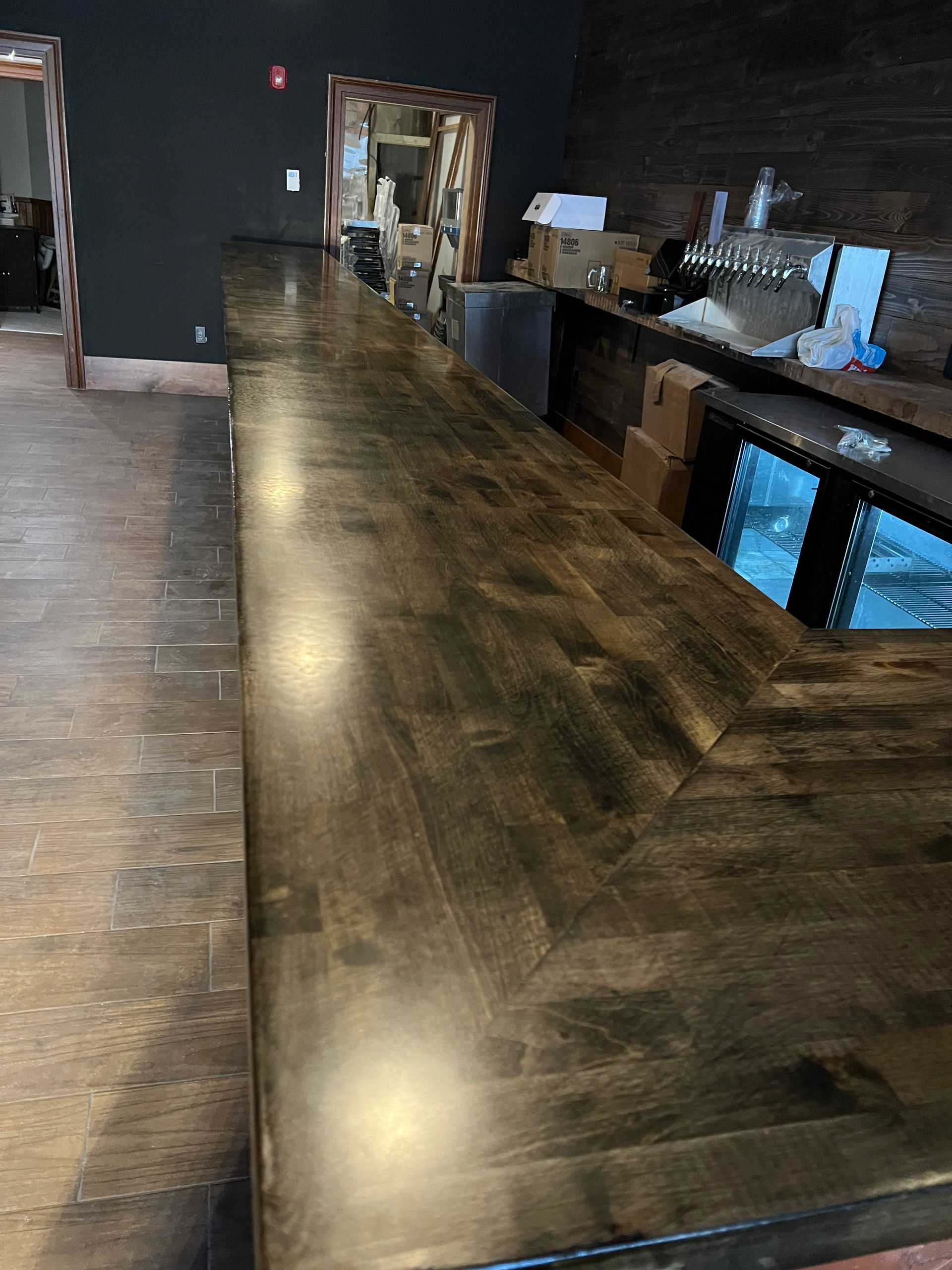 Long wooden bar counter in a dimly lit restaurant interior