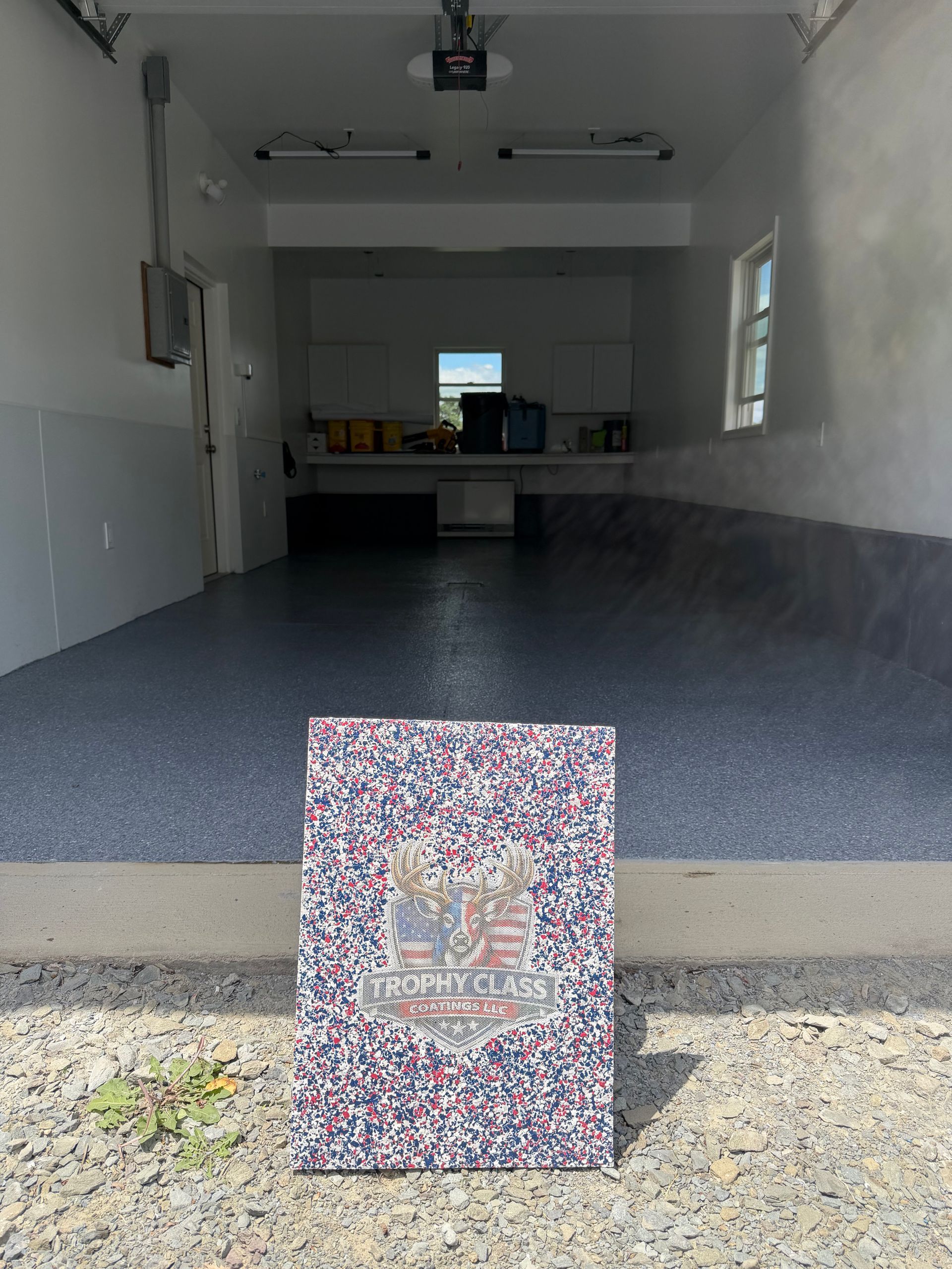 Open garage with carpeted floor, workbench at back, and a colorful patterned box in the foreground