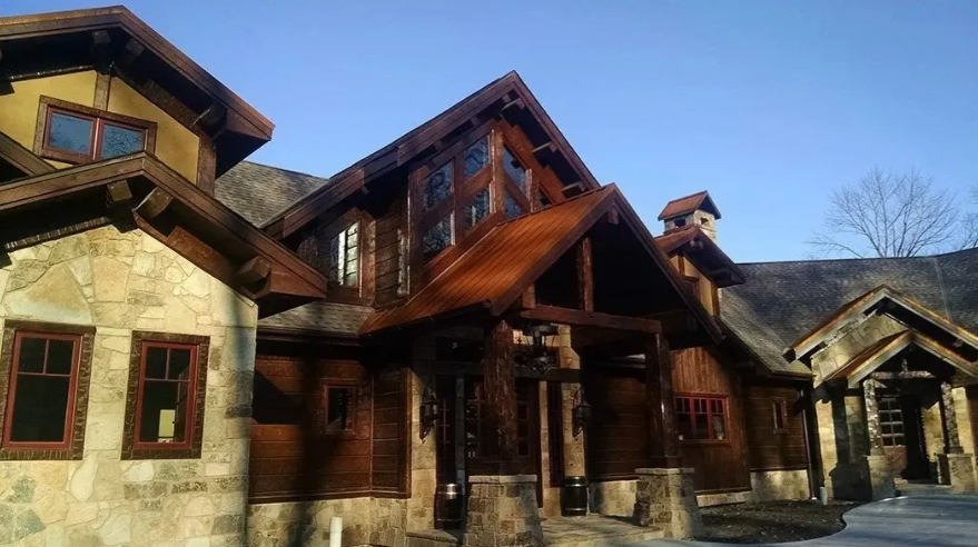 Rustic lodge-style building with stone and wood exterior under a clear blue sky