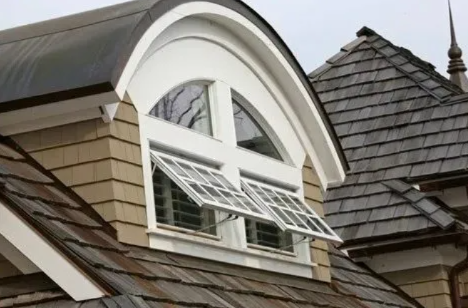 Dormer window with open white shutters on a shingled house roof