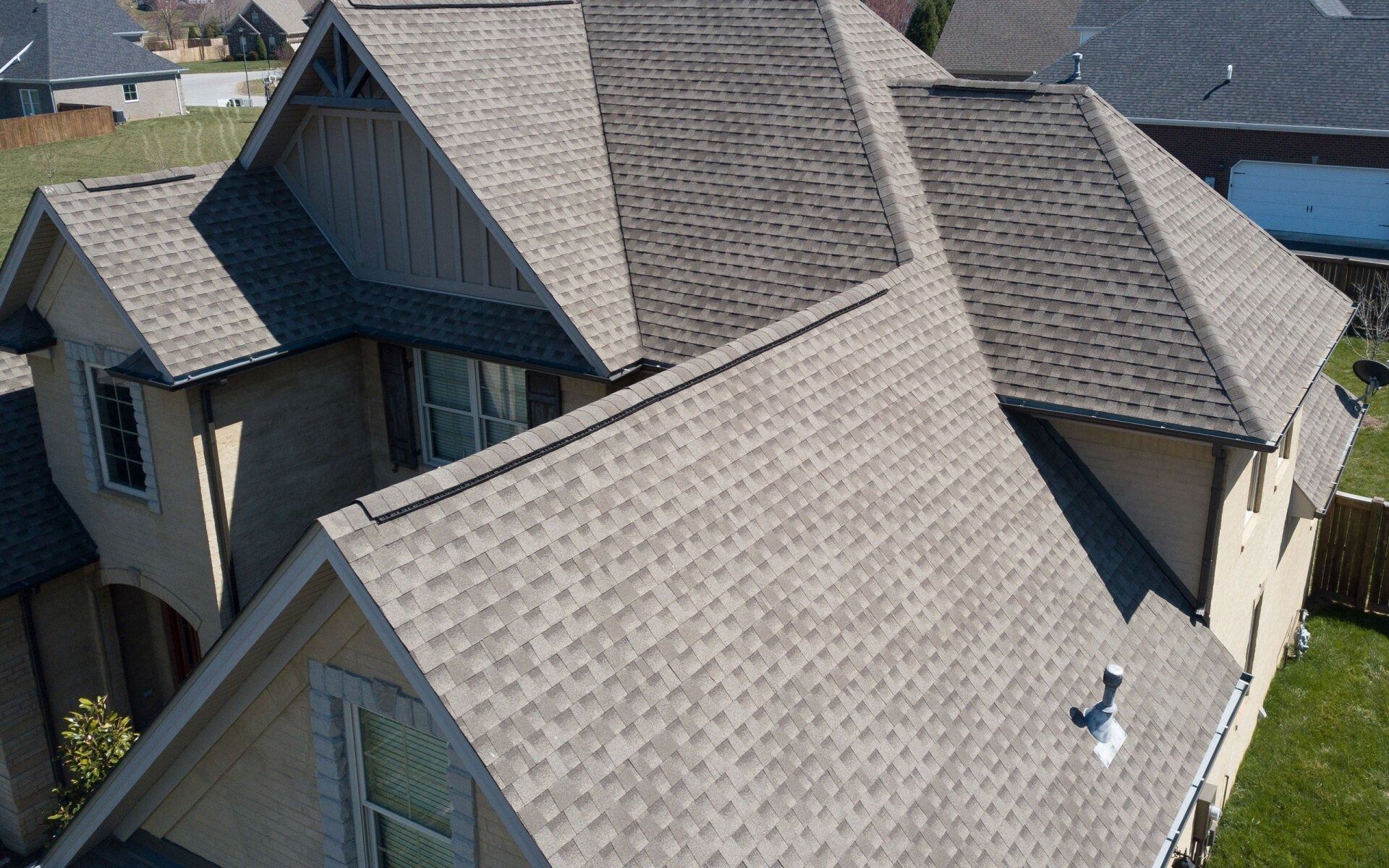 Aerial view of a house roof with gray shingles and multiple gables.